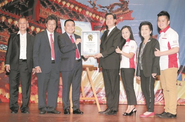 王乃志（左4）见证雪隆海南会馆荣获「全国最高的春联」马来西亚纪录大全。左起为陈玉良、黄良友、丁才荣、李佩玲、陈孟龄及黄程运。