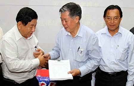 新山发展华小工委会主席黄剑锋（左）呈交签名表格予邹寿汉。右为黄循积。