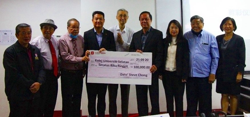 张润安（左6）在启用礼上移交10万令吉捐款予南方大学学院，由陈洺臣（左4）代表接领。