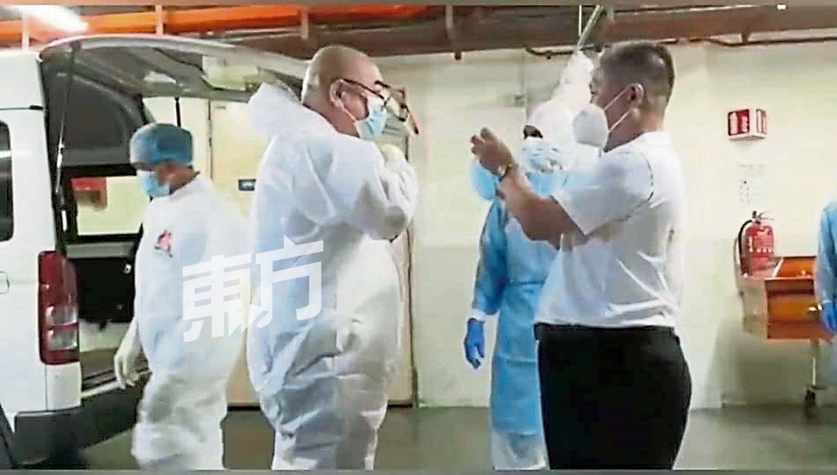 蔡志明（前左）穿上个人防护服到医院领取冠病死者的尸体。他表示，既然当初决定要做这件事，就不会再去多加担心和忧虑，唯有在过程中完整依照政府制定的标准作业程序。