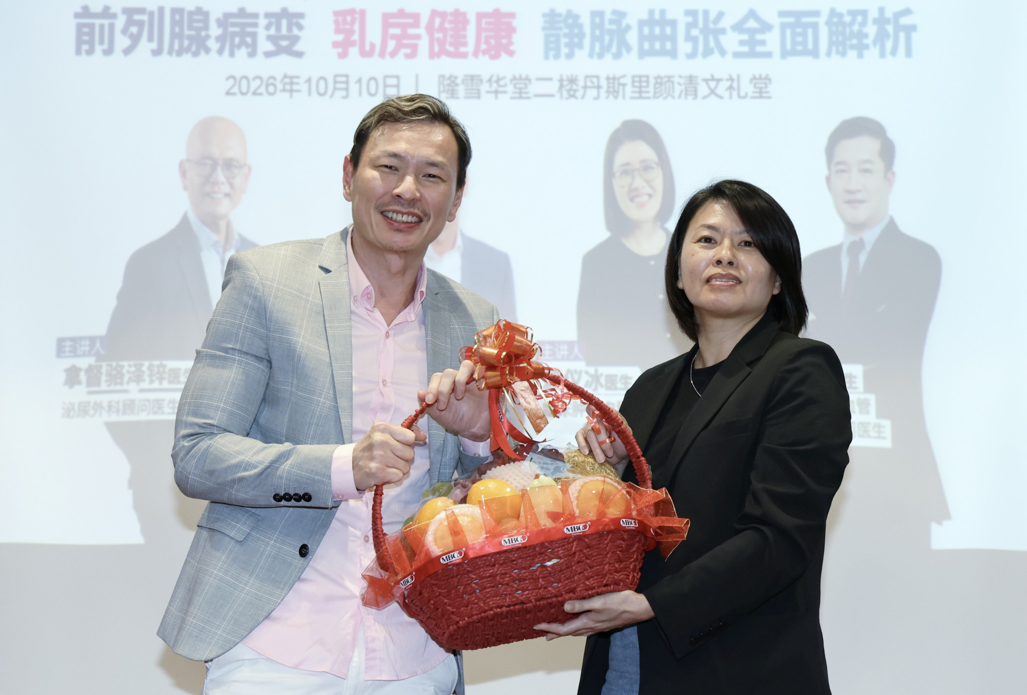 《东方日报》总编辑杨紫玲（右）颁发水果篮予黄楚竤医生。