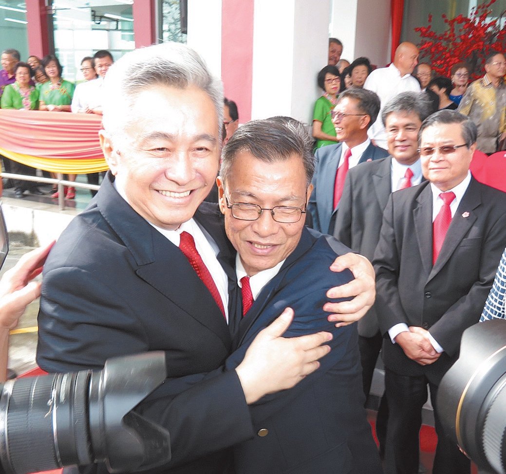 撇开选举激烈斗争及纠纷，林华龙（左）及陈永明（右）暂放下成见，在森华堂大厦开幕礼上礼貌握手及相拥。