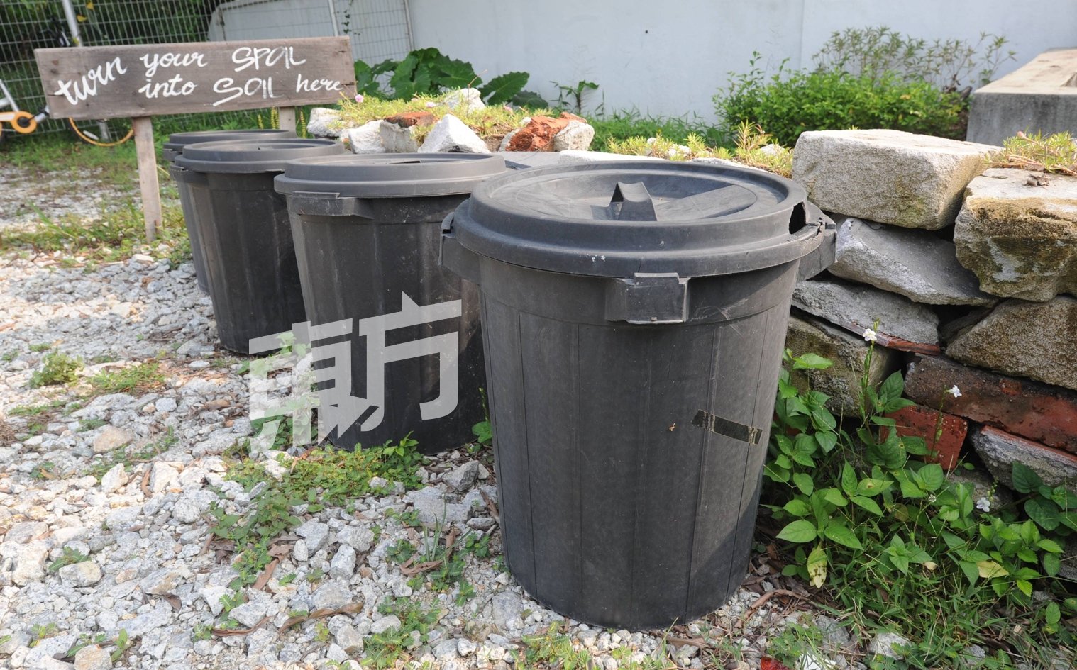 菜园入口处放置了几个黑色大垃圾桶，鼓励附近居民把厨余带过来做堆肥之用。
