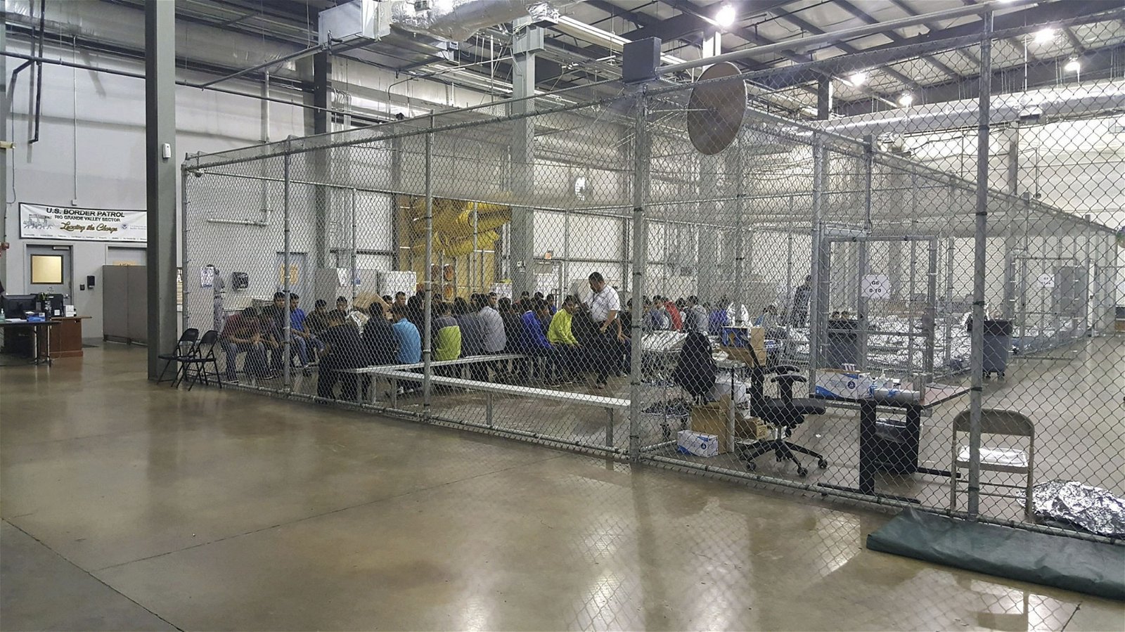 非法入境的成年移民，被拘禁在麦卡伦拘留设施的特定网笼内，等候边防警卫队的安排。