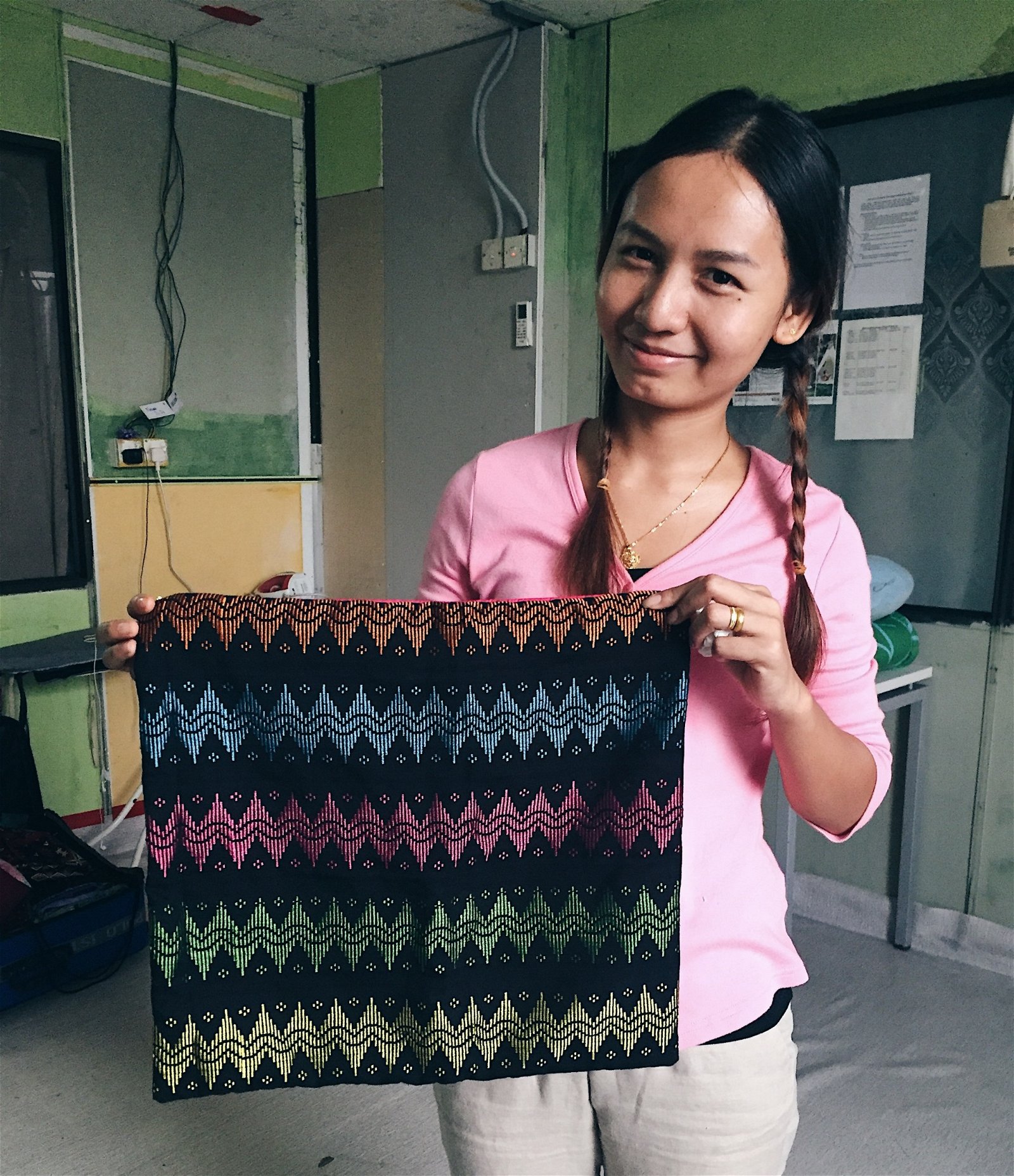 图为Tanma联盟下Paw Ghee组织缅甸妇女展示手工编织的沙发枕套。