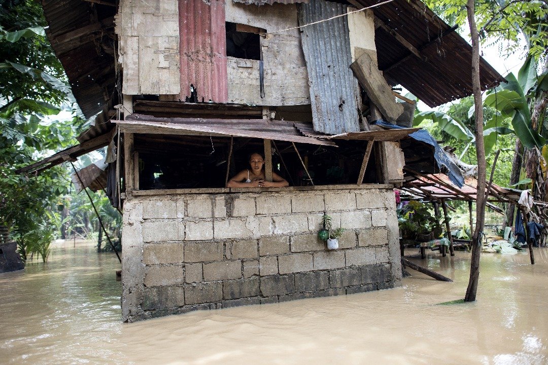 受“安比”影响，菲律宾马尼拉大都会区东部的马里基纳河水水位暴涨，引发洪涝。附近的住区被水淹，民众在屋内等待积水消退。