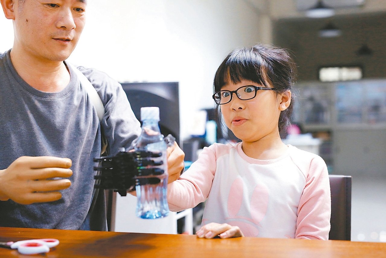8岁的彭小妹她因意外右手烧伤，配戴上张宪良研发的机械手，让她第一次握住保特瓶，露出惊异的神情。