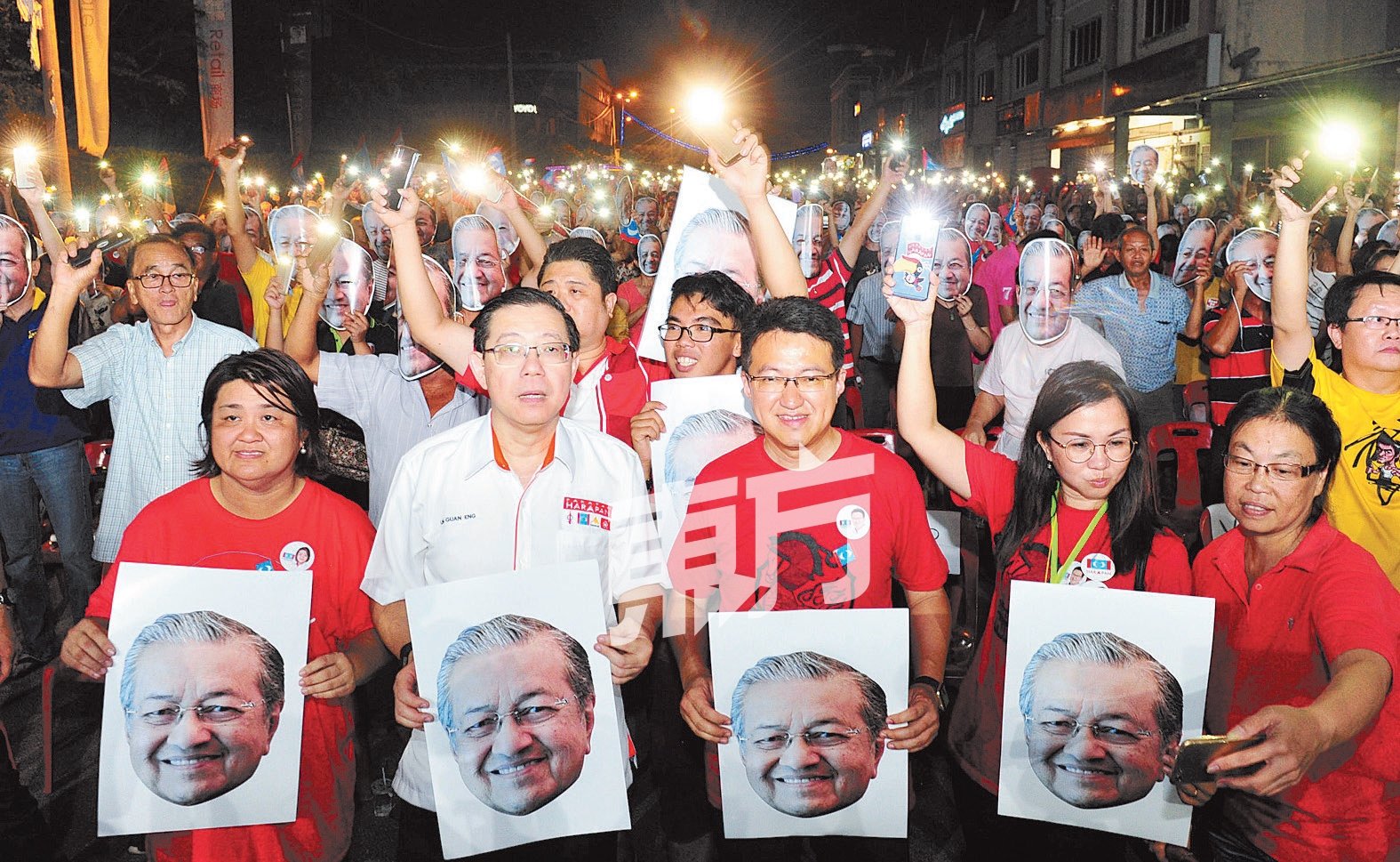 满城尽是马哈迪！希盟领袖一同举起印有敦马哈迪肖像的卡片，与戴上敦马肖像面具的会民众合照。前排左起为周碧珠、林冠英及刘镇东。 （摄影：杨金森）