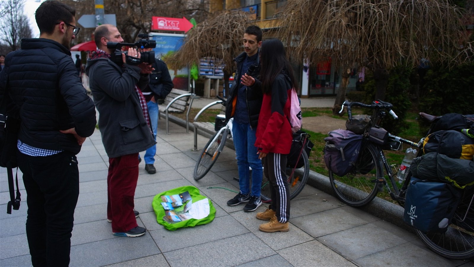 两人在普里什蒂纳广场上摆摊卖明信片，一群记者对此感兴趣，也就这样上了科索沃电视。