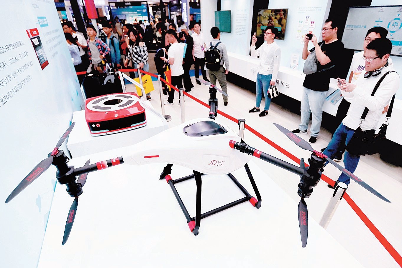 中国网购平台“京东”，在会展上展出一款送货无人机，吸引科技爱好者驻足拍照。