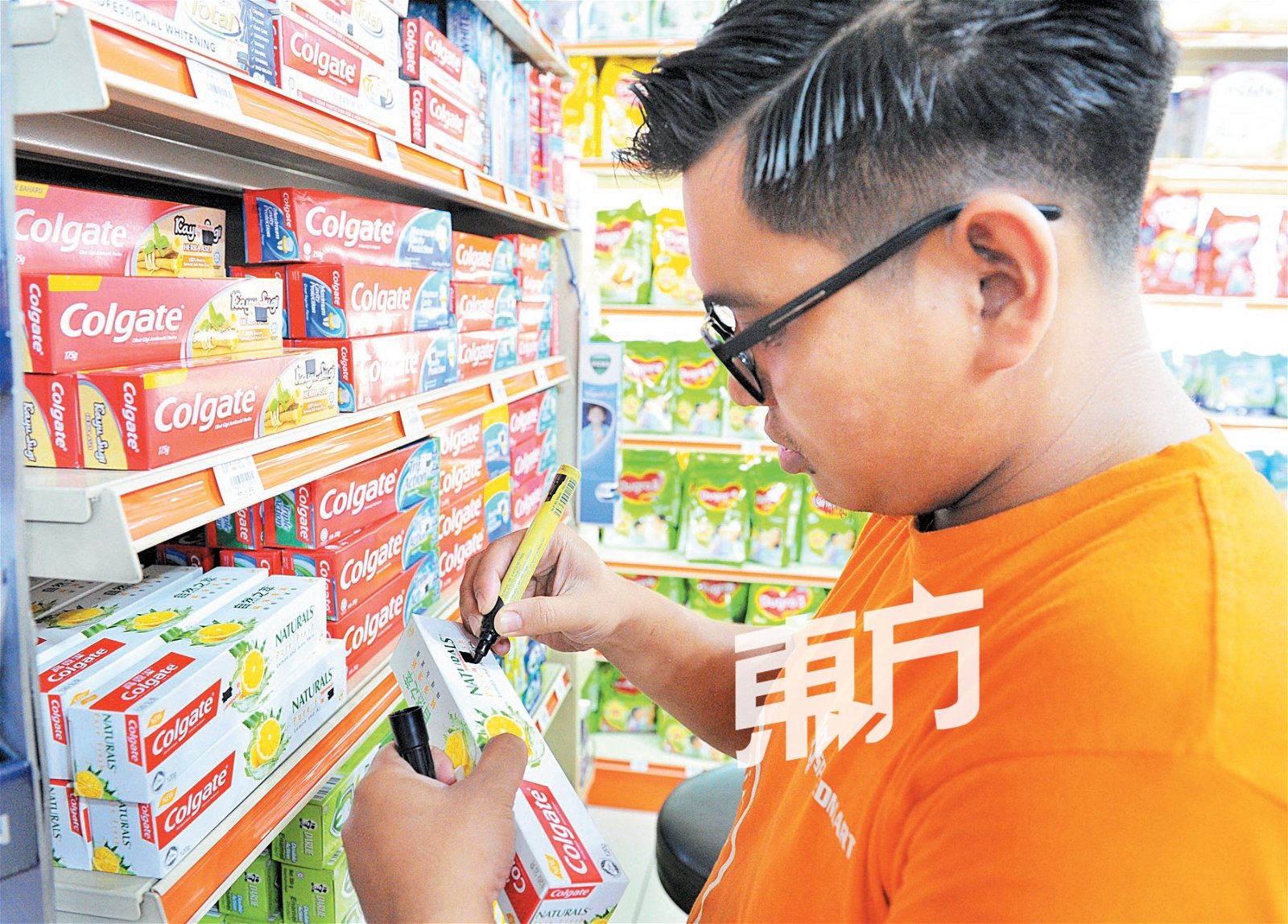 为了迎接“消费税零税率”措施，连锁超市员工以马克笔涂黑原价，准备贴上新的价格标签。 （摄影：陈为康）