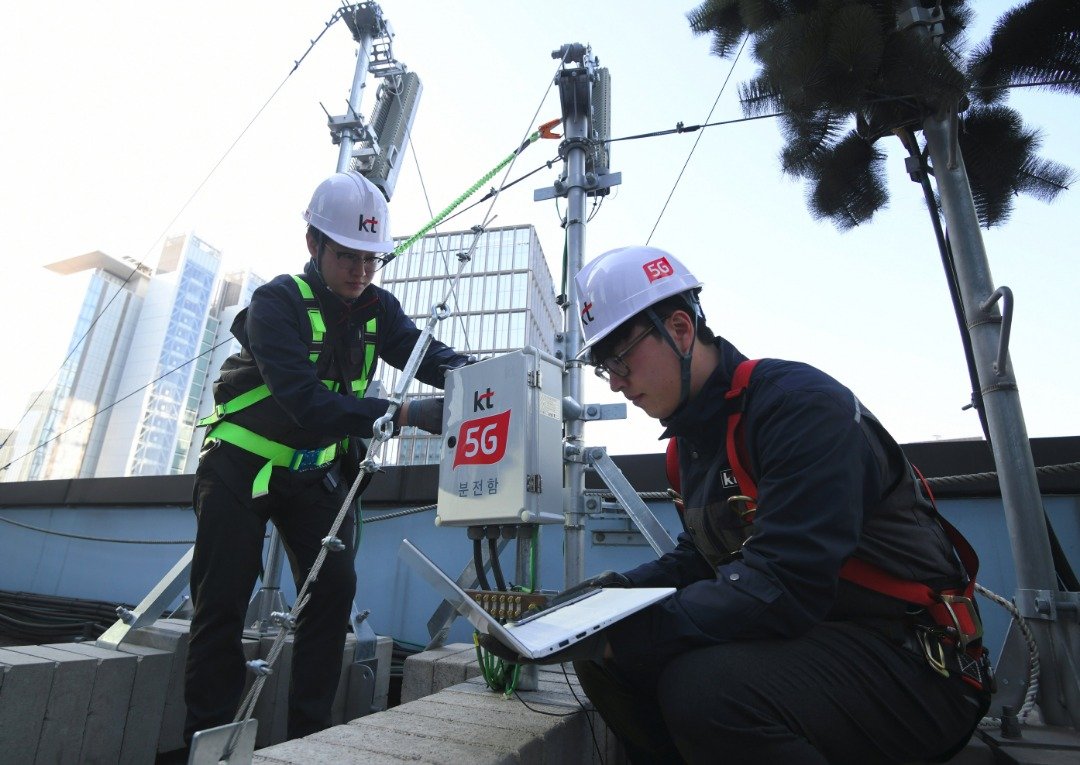 韩国最大行动电信商SK电讯的工作人员，周四在首尔市一座建筑的天台，装上5G网络设备。
