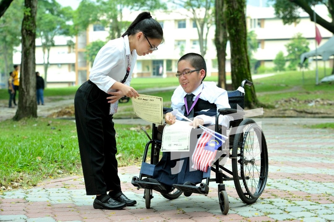 来自大山脚的姚妮菊（左起）及黄振翔，虽然天生残疾，却靠自己后天的努力成功考上槟城理科大学。（摄影：蔡开国）