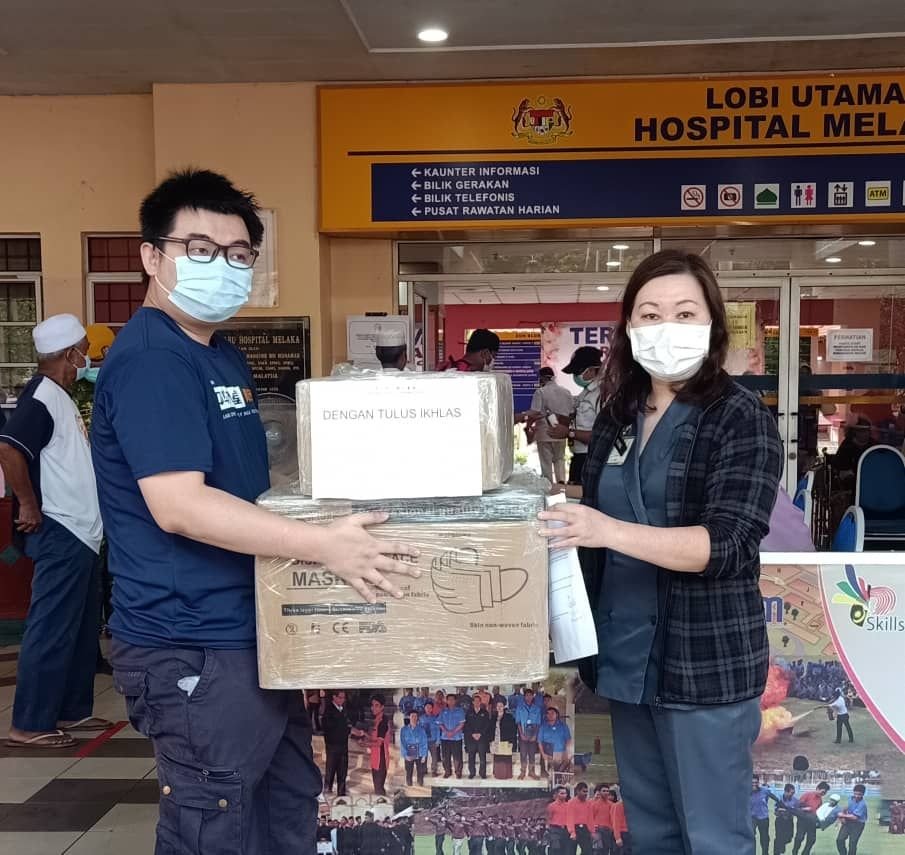 华总青全国署理总团长兼甲华堂青团长吴汉坤（左）协助移交物资予马六甲中央医院代表。