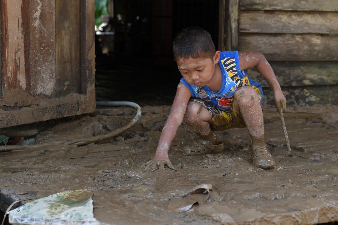 4岁的莫哈利礼端在布满泥泞的家园嬉戏