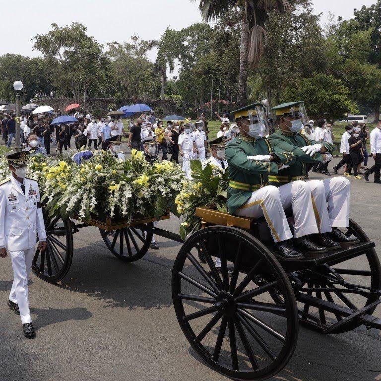 载著菲律宾已故前总统阿奎诺骨灰的车队前往墓园。
