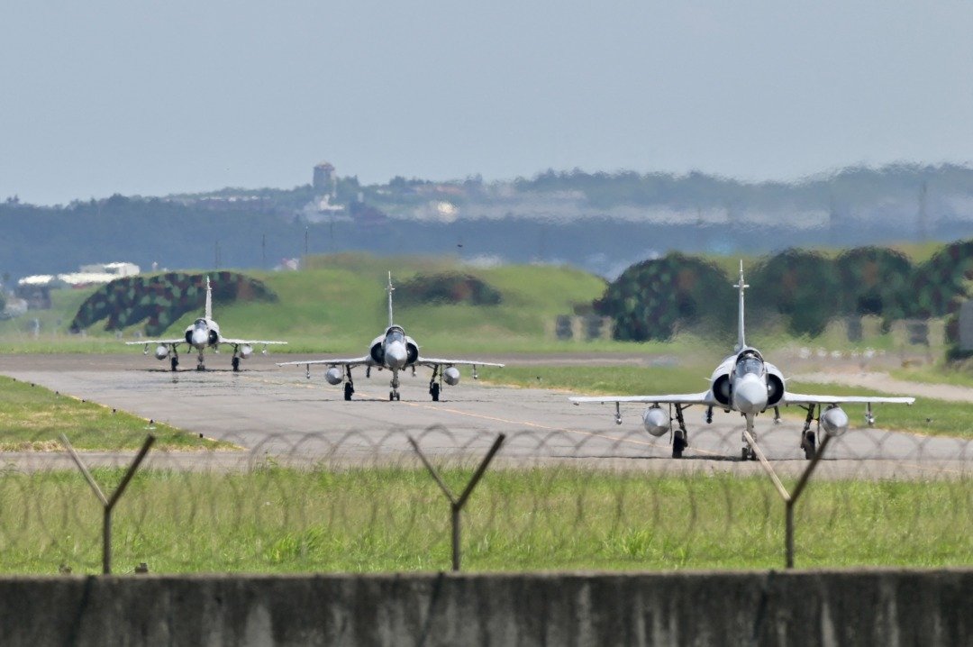 周五在新竹空军基地，一架台湾空军飞机降落时，幻影2000-5战斗机在旁边。（图取自路透社）
