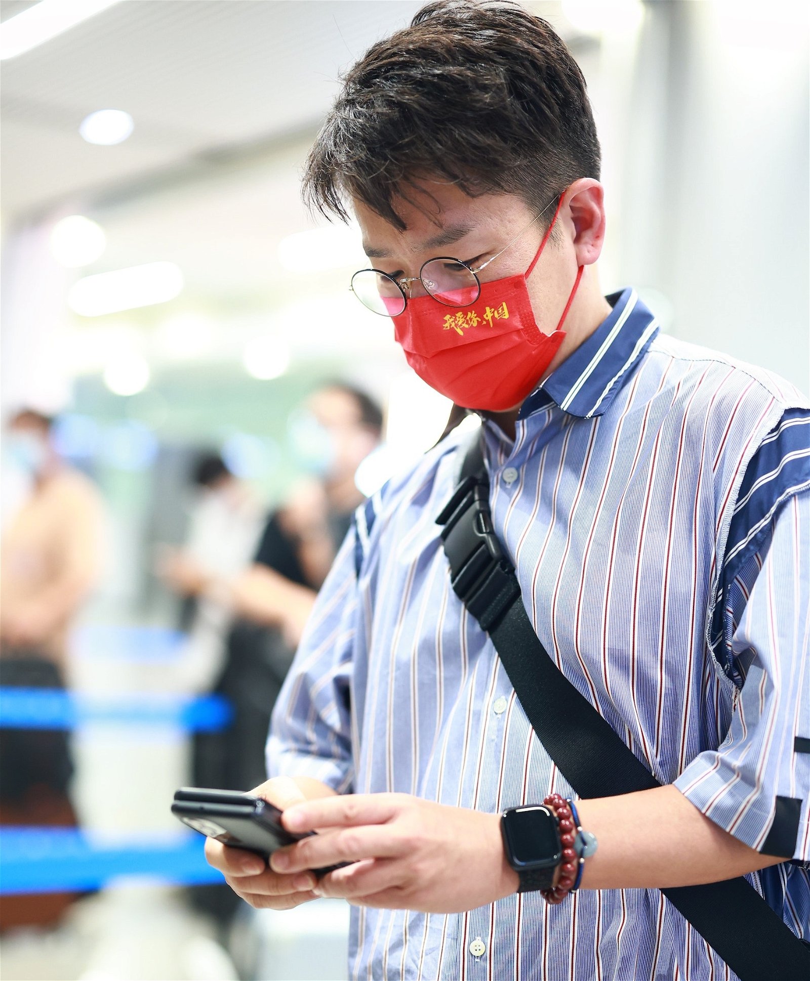 林晓峰戴上印着“我爱你，中国”的红色口罩现身机场。（图取自网络）