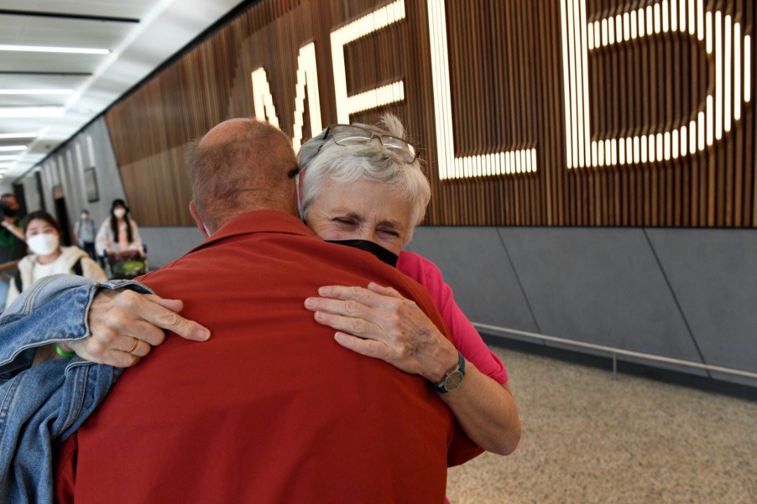 在墨尔本国际机场，抵达的旅客看见近两年不见的亲属后喜极而泣的拥抱彼此。（图取自法新社）