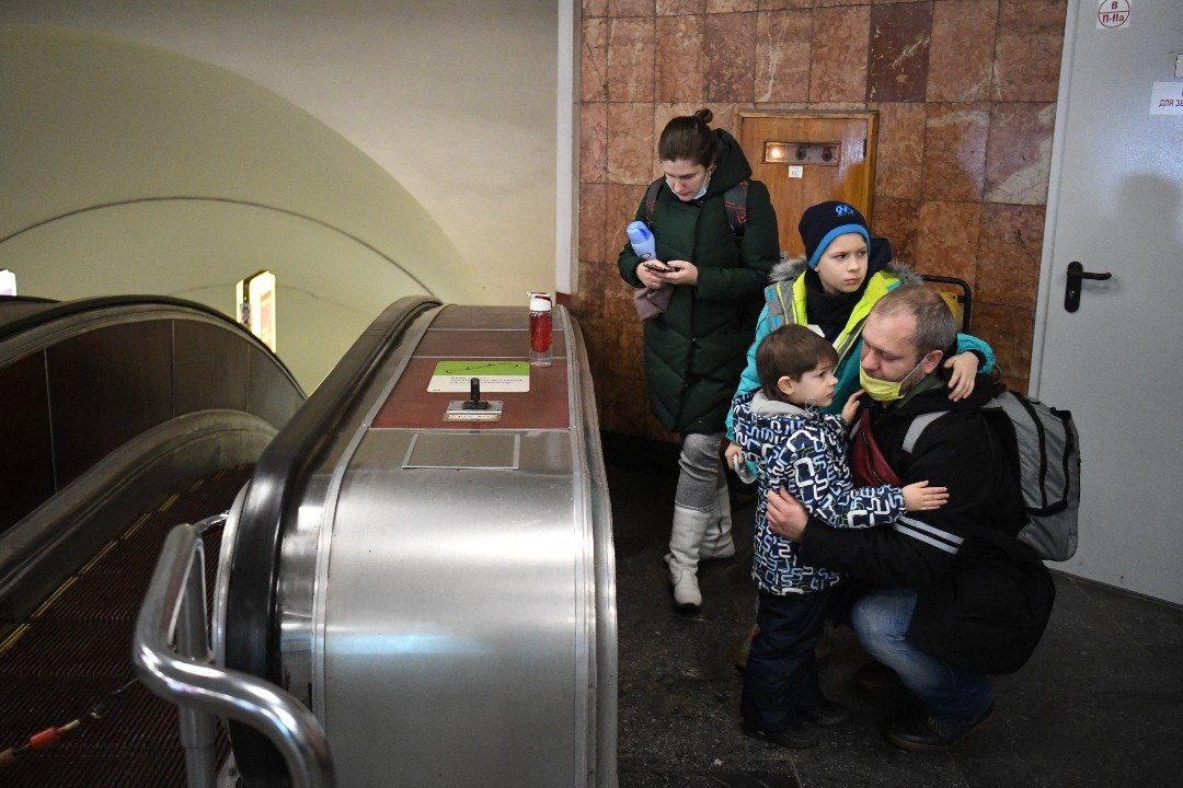 基辅地铁站成了民众携带家眷避难的场所，伴随父母逃难的孩童也面露愁色。（图取自法新社）
