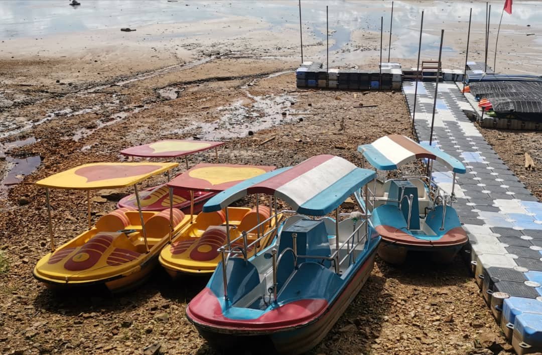 武吉美拉湖水骤降后，供游客乘坐的船只搁在沙滩上。