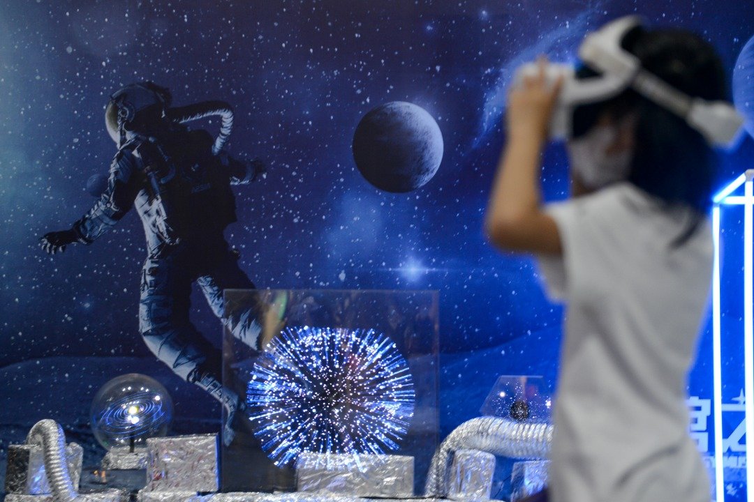 重庆科技馆上月28日晚举行“点亮科学梦想”科技馆之夜系列活动，小朋友在“科学元宇宙”版块进行VR交互体验。（图取自中新社）