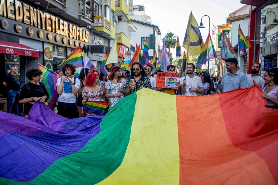 塞浦路斯LBGT+社群于18日举办游行，与会者拉起一大面彩虹旗游行。（图取自法新社）