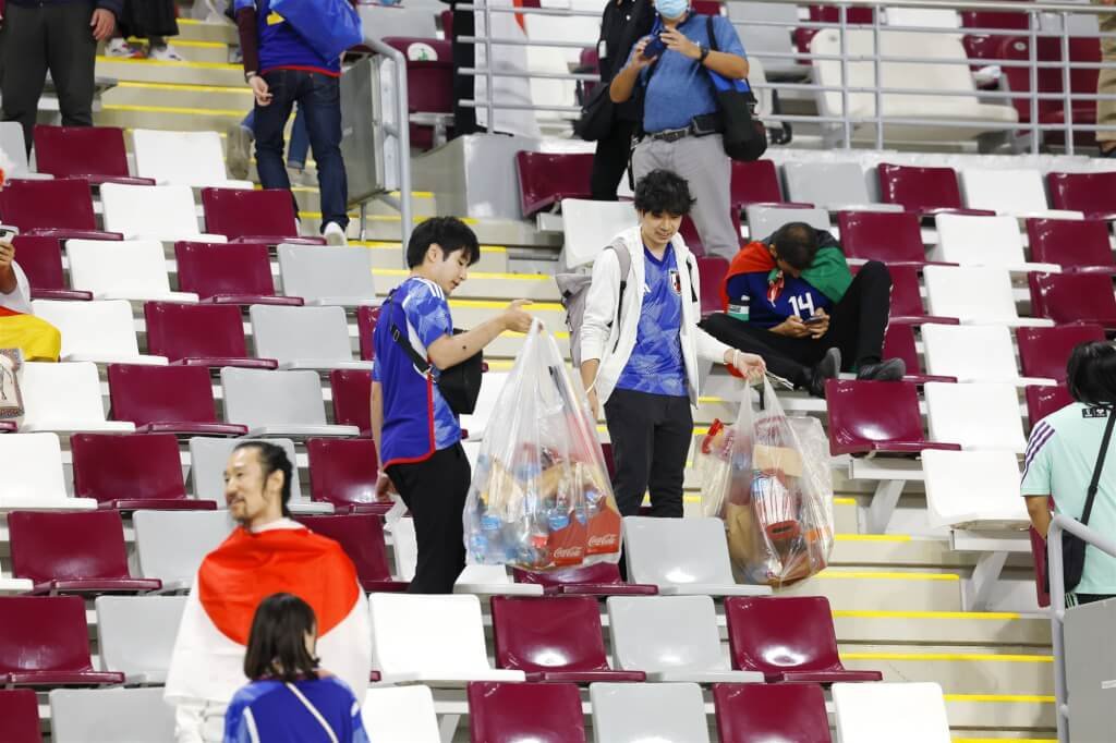 日本球迷23日于赛后主动捡拾观众席上的垃圾。（共同社）