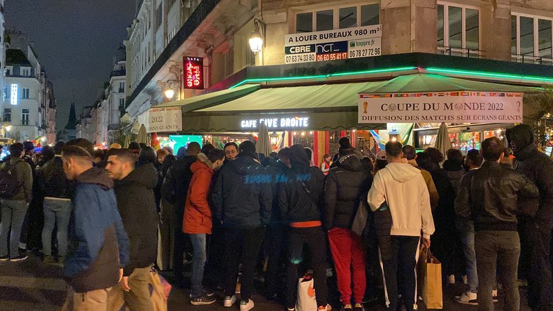 巴黎一家餐厅在门前挂起两大张“世界杯，超大萤幕转播球赛”宣传，门庭若市。不得其门而入的民众堵在门口，形成四、五层的人肉围墙。一旁球迷说：“无论如何，有法国队就必须支持。”（中央社）
