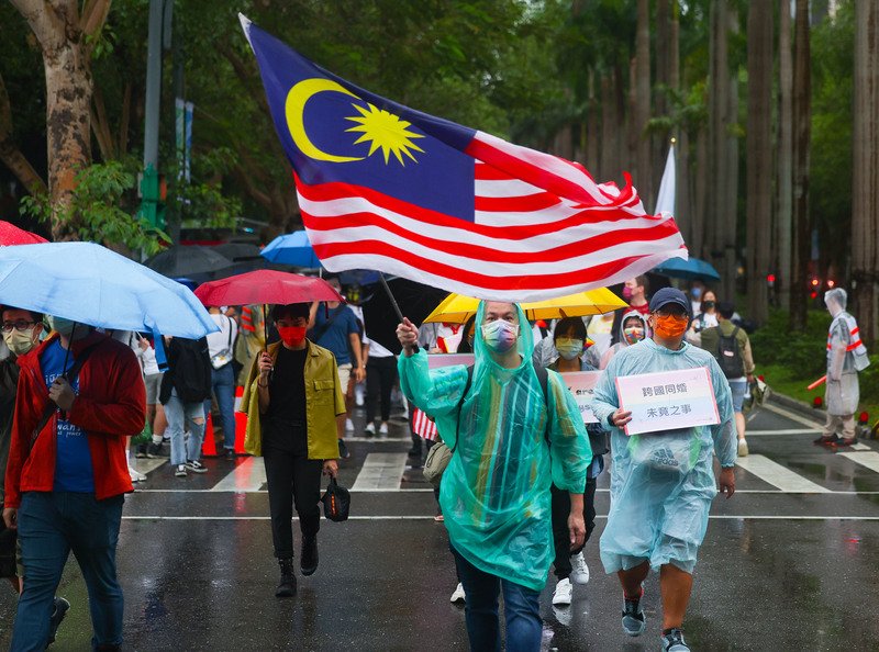 游行现场有参与者挥舞马来西亚国旗，力挺性别平权、跨国同婚。（图取自中央社）
