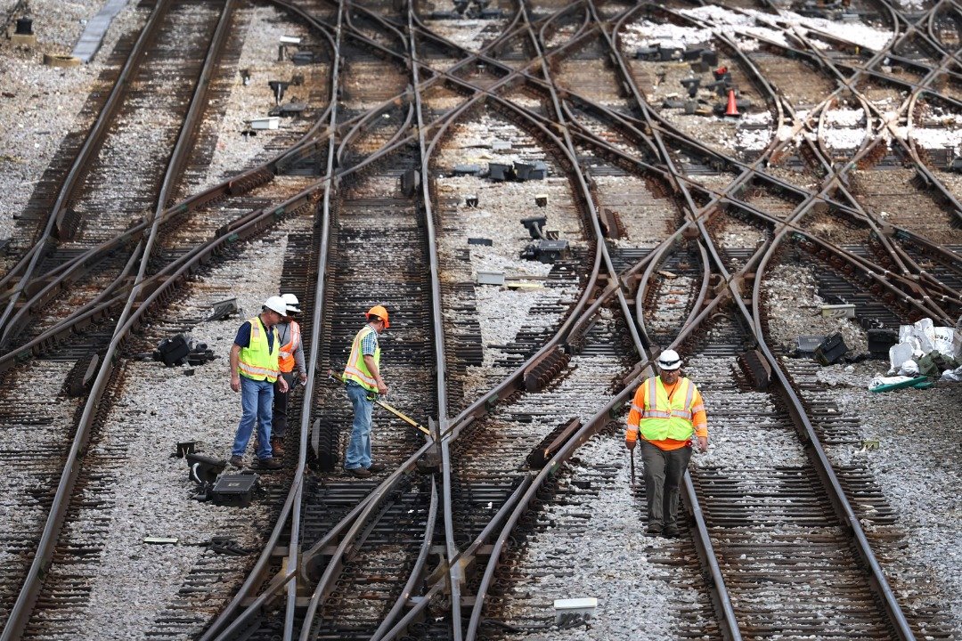 在伊利诺伊州芝加哥市郊外的Metra/BNSF铁路站场，工人们当地时间周二在检查铁轨。（图取自法新社）
