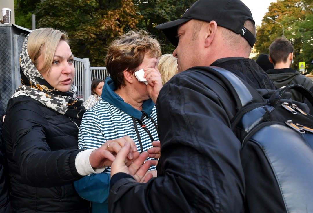 在俄罗斯第2大城圣彼得堡的一个征兵站，一名年长妇女周二泪别被征召的亲人。（图取自法新社）