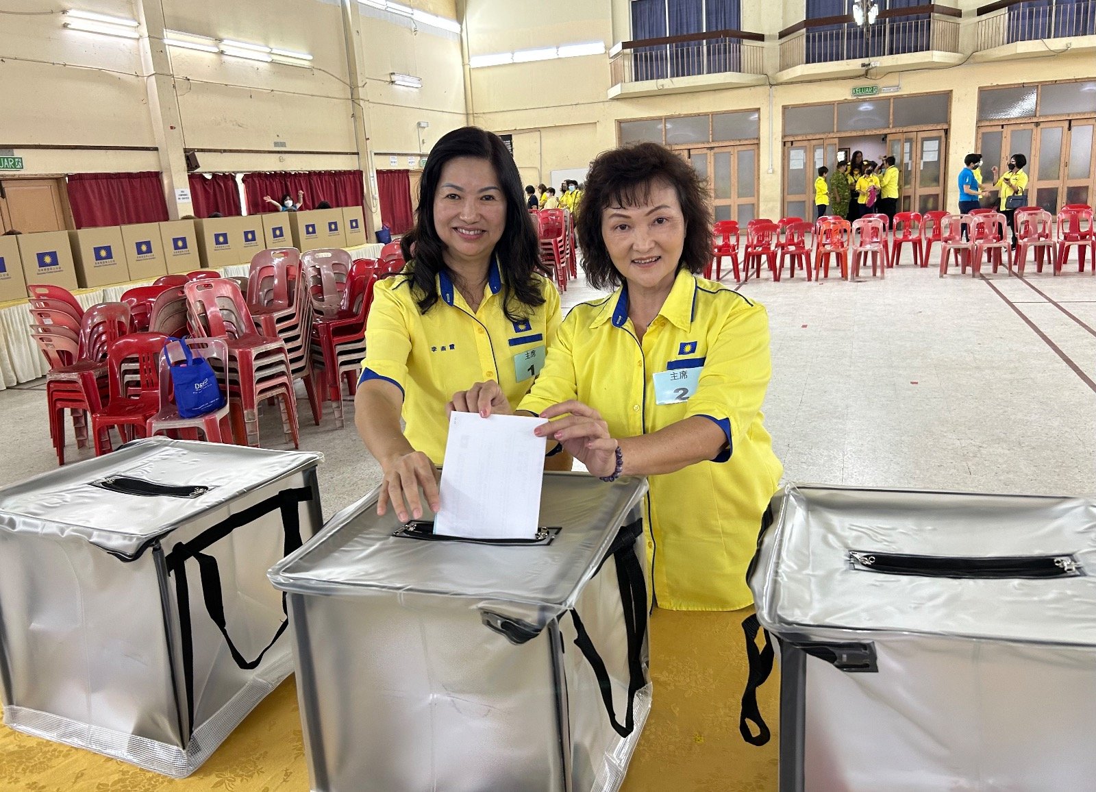 竞选新届马华霹雳妇女组主席李燕霞（左起）和谭凤娇一同将个人投票放入票箱。