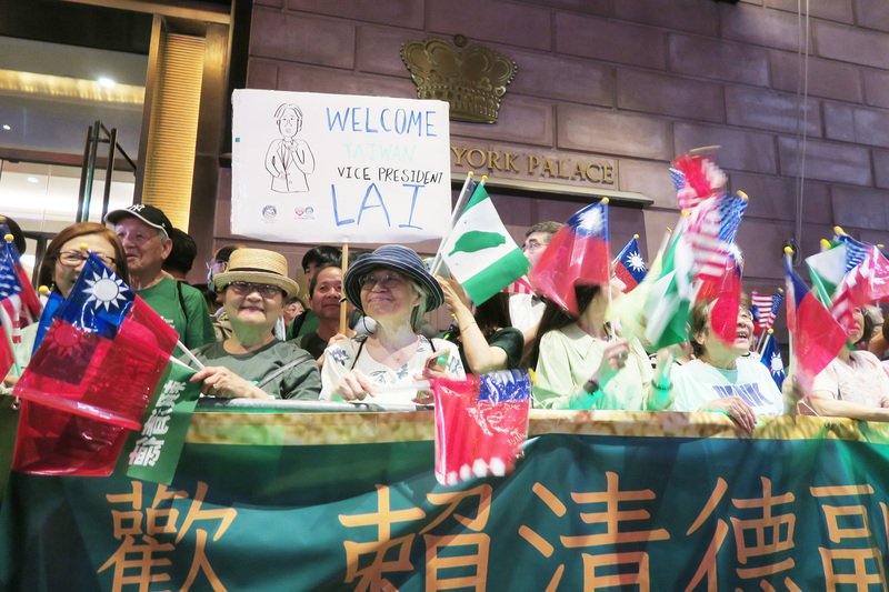 赖清德支持者在酒店外挥舞旗帜、高举欢迎标语。（图取自中央社）