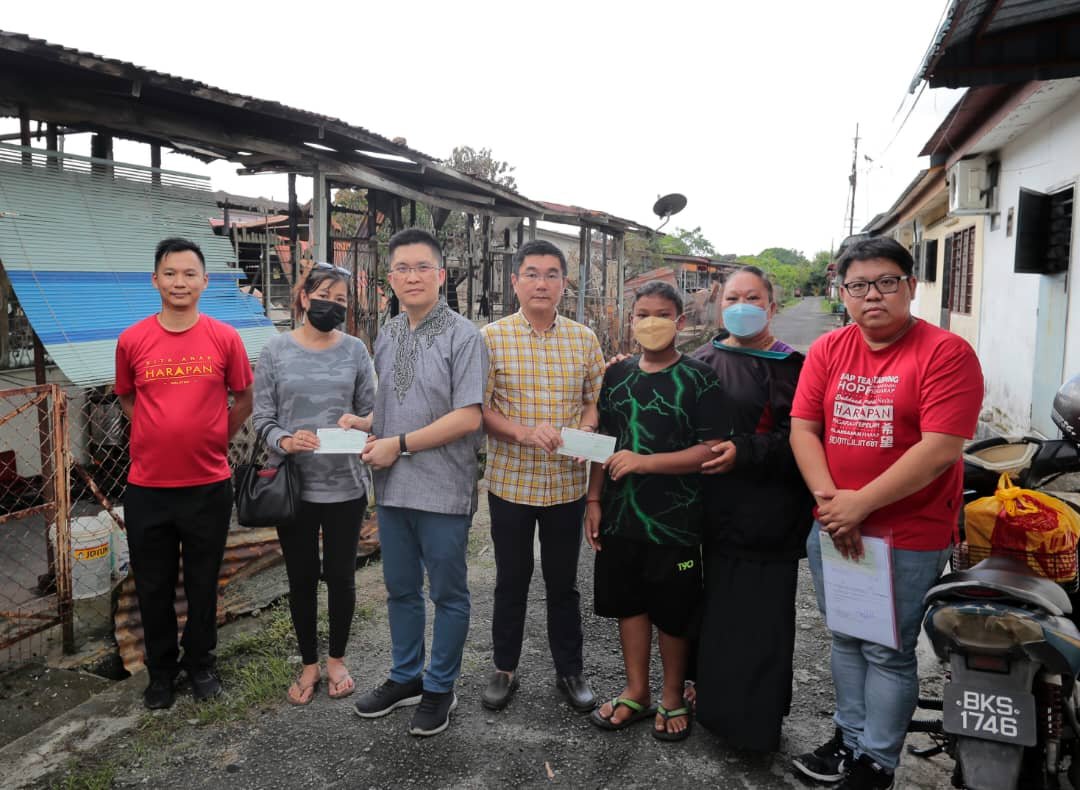 黄家和（左3起）与郑国霖移交紧急援助金支票，予受灾的2户居民，协助他们度过难关。
