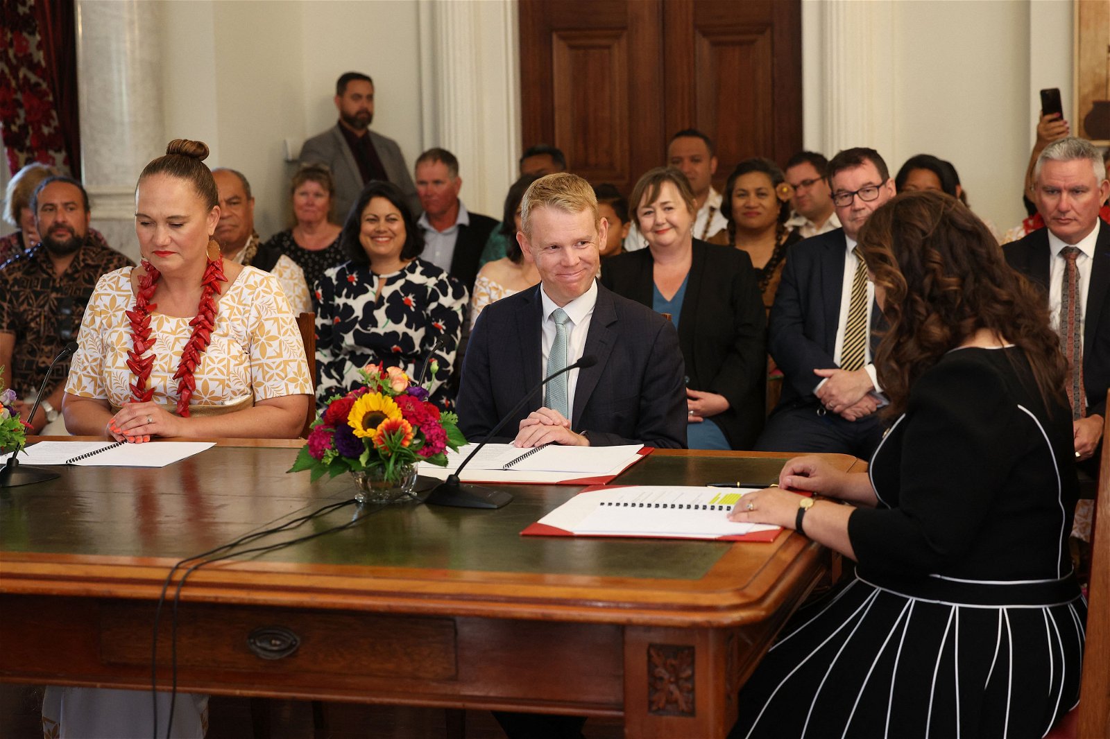 纽西兰新任总理希普金斯（中）和副总理塞普洛尼（左），周三于惠灵顿总督府在总督基罗（右）的见证下宣誓就职。（图取自法新社）