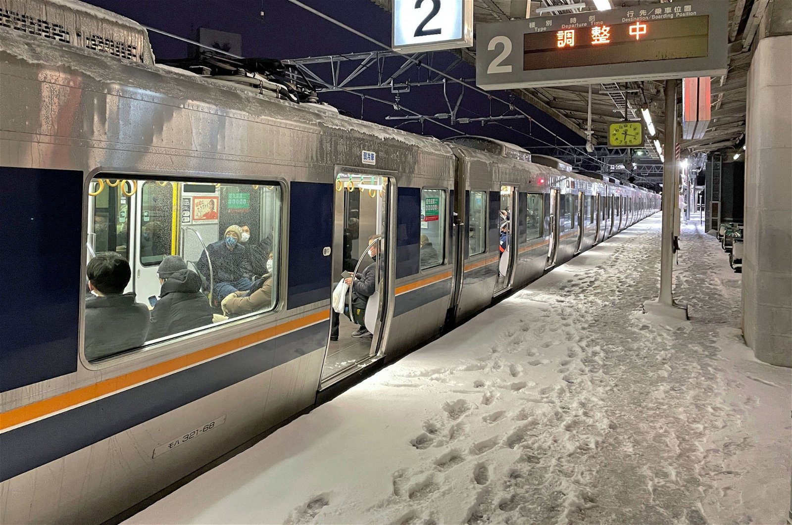 一辆列车周三停在京都西大路站，月台上布满积雪。（图取自共同社/路透社）