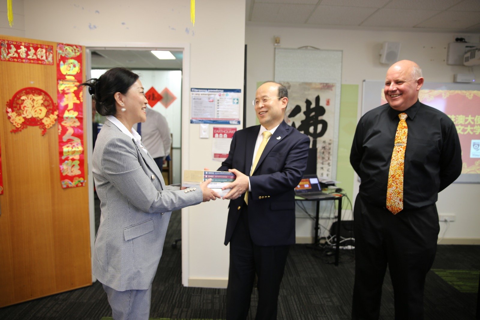 中国驻澳洲大使肖千周一访问尔斯达尔文大学孔子学院期间，向孔子学院院长艾米（左）赠送中文图书。（图取自中新社）