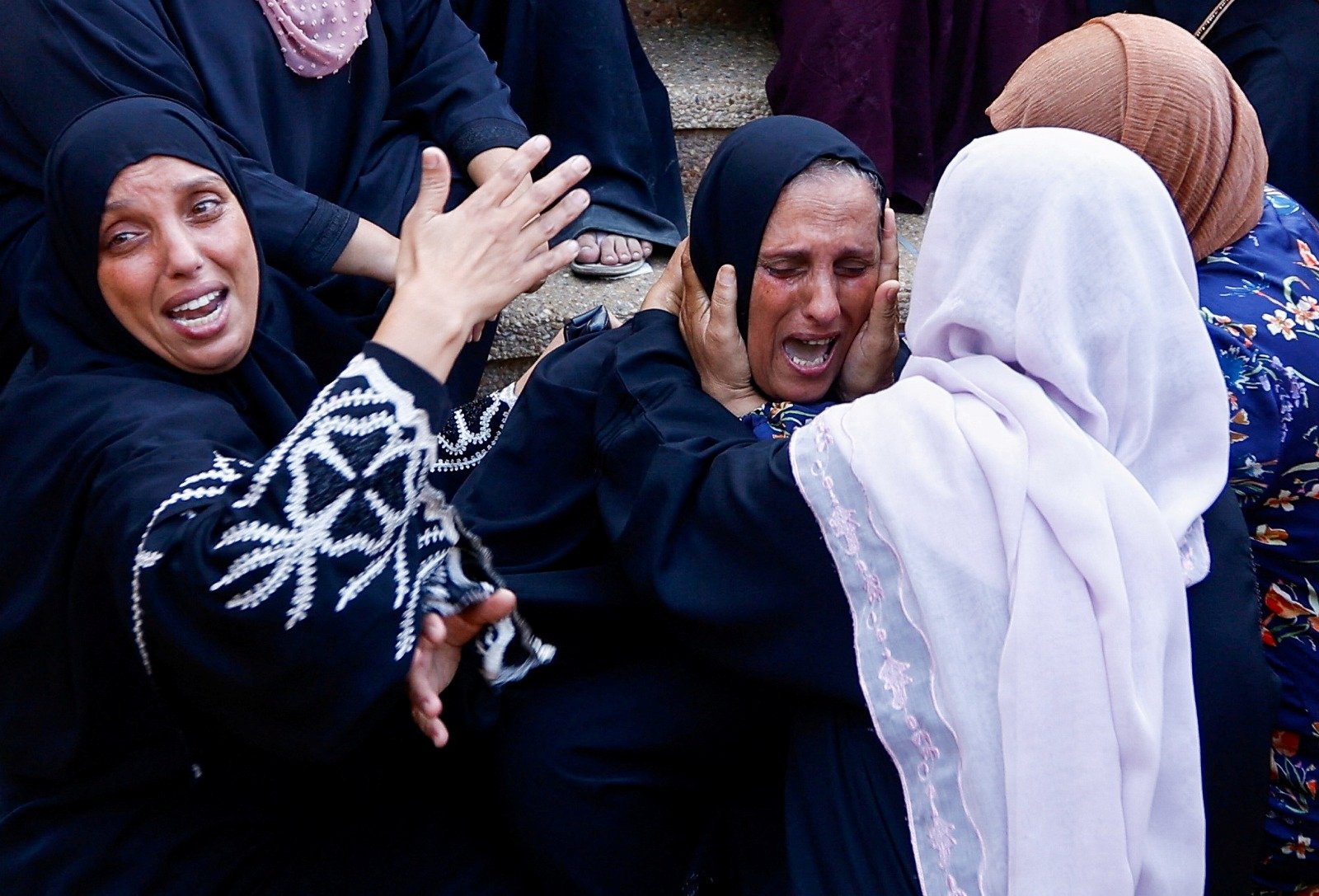 周三在加沙地带南部汗尤尼斯的纳赛尔医院，数名巴勒斯坦妇女看到因空袭遇难的亲属尸体时悲痛大哭。（图取自法新社）