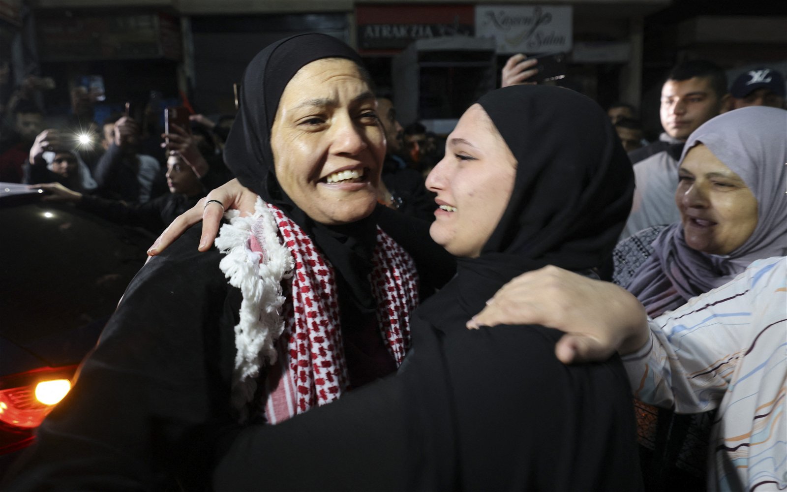以色列当地时间周五从监狱中释放了39名巴勒斯坦妇女和儿童，其中一名巴勒斯坦女性（左）当天获释后兴奋地拥抱她的亲人。（图取自法新社）