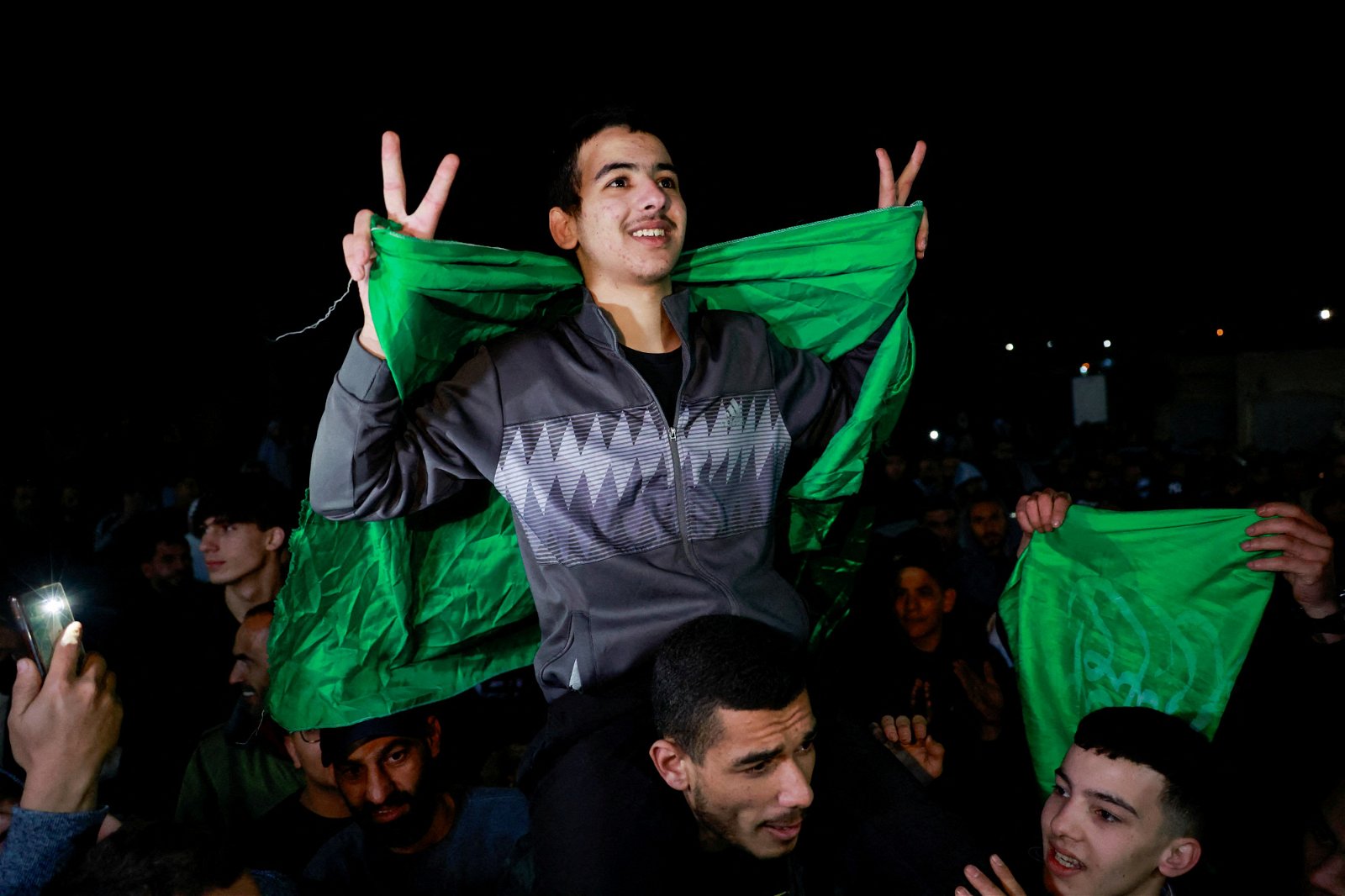 当地时间周五从以色列监狱获释的巴勒斯坦青少年开心地做出手势。（图取自路透社）