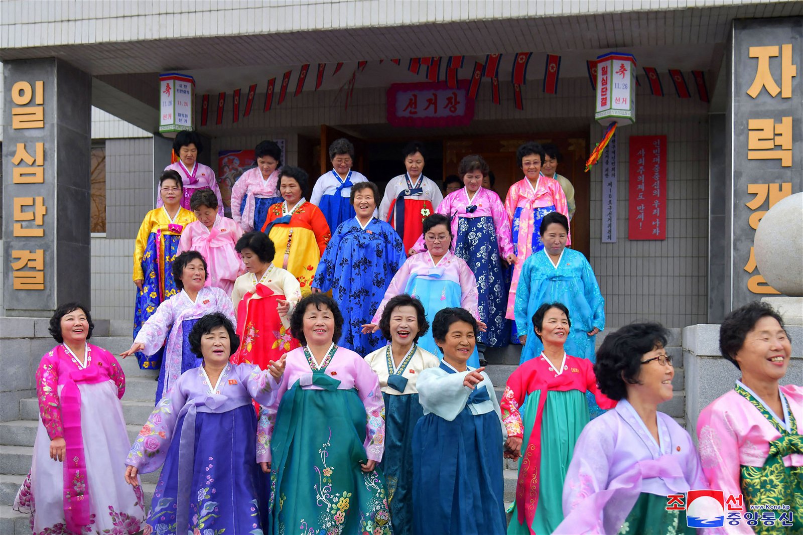 朝鲜周日举行地方选举，当地妇女开心地站在投票站外等候投票。（图取自朝中社/法新社）