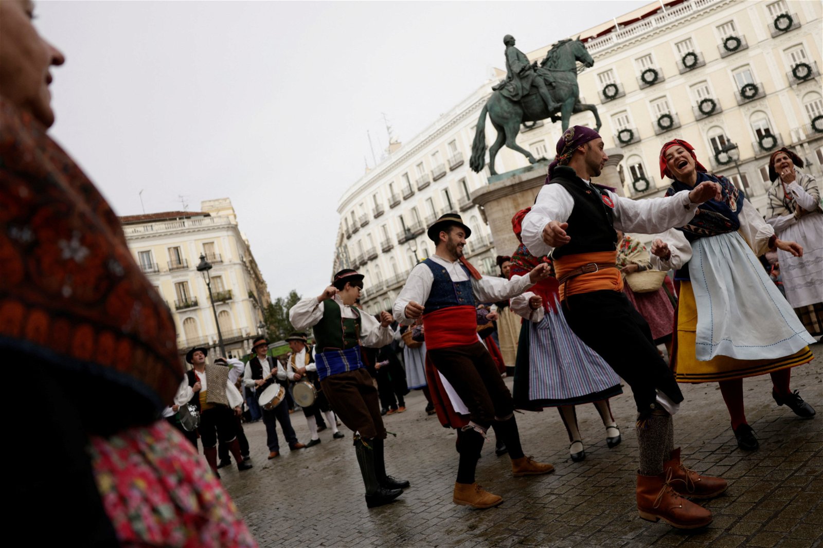 身穿传统服装的人们当地时间周日，在羊群经过西班牙马德里市中心时翩翩起舞。（图取自路透社）