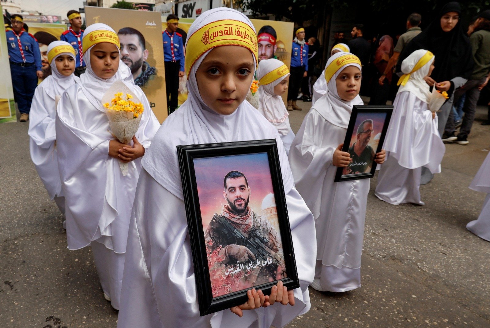 在黎巴嫩Nabatieh上周五举行的葬礼上，女孩们举著真主党成员侯赛因、马哈茂德和塔哈的照片，他们在以色列和真主党位于黎巴嫩南部的紧张局势中被杀。（图取自路透社）