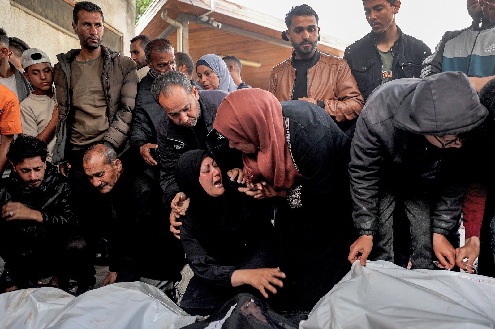 周三在加沙地带南部拉法的纳贾尔医院，一名妇女安慰著另一名妇女，后者的亲人在以军周二晚的空袭中丧生。（图取自法新社）