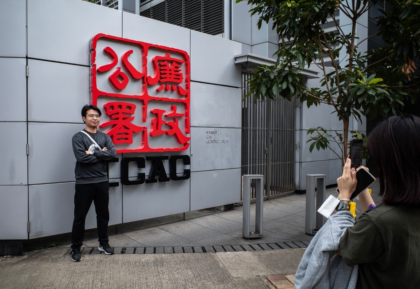 有市民于周四在位于香港渣华道的廉政公署总部的标志处拍照留念。（图取自中新社）