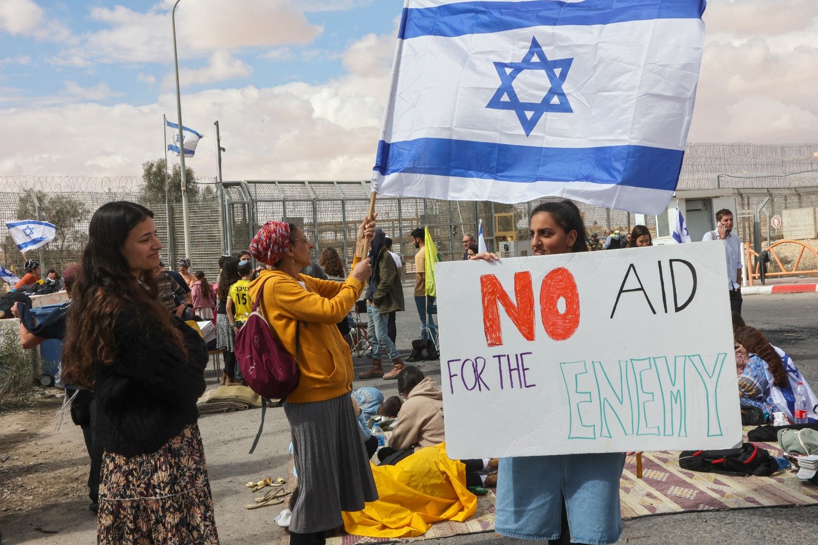 以色列示威者本月18日聚集在与埃及接壤的以色列南部尼扎纳过境点围栏旁，试图阻止人道主义援助货车进入加沙地带。（图取自法新社）
