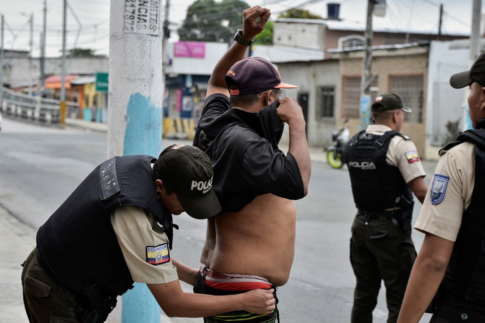 在厄瓜多尔瓜亚基尔，一名警察周二当街对一名男子搜身。（图取自路透社）