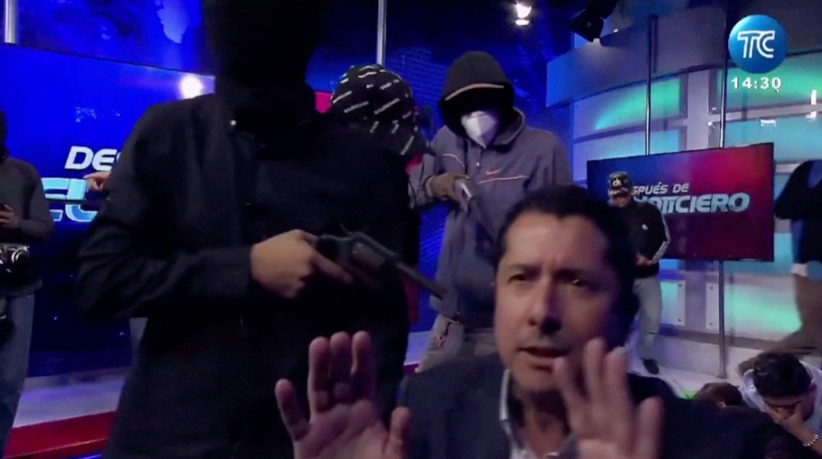 周二在厄瓜多尔TC电视台，蒙面枪手闯入后用枪指著电视节目主持人卡尔德隆，接管了电视直播。（图取自路透社）