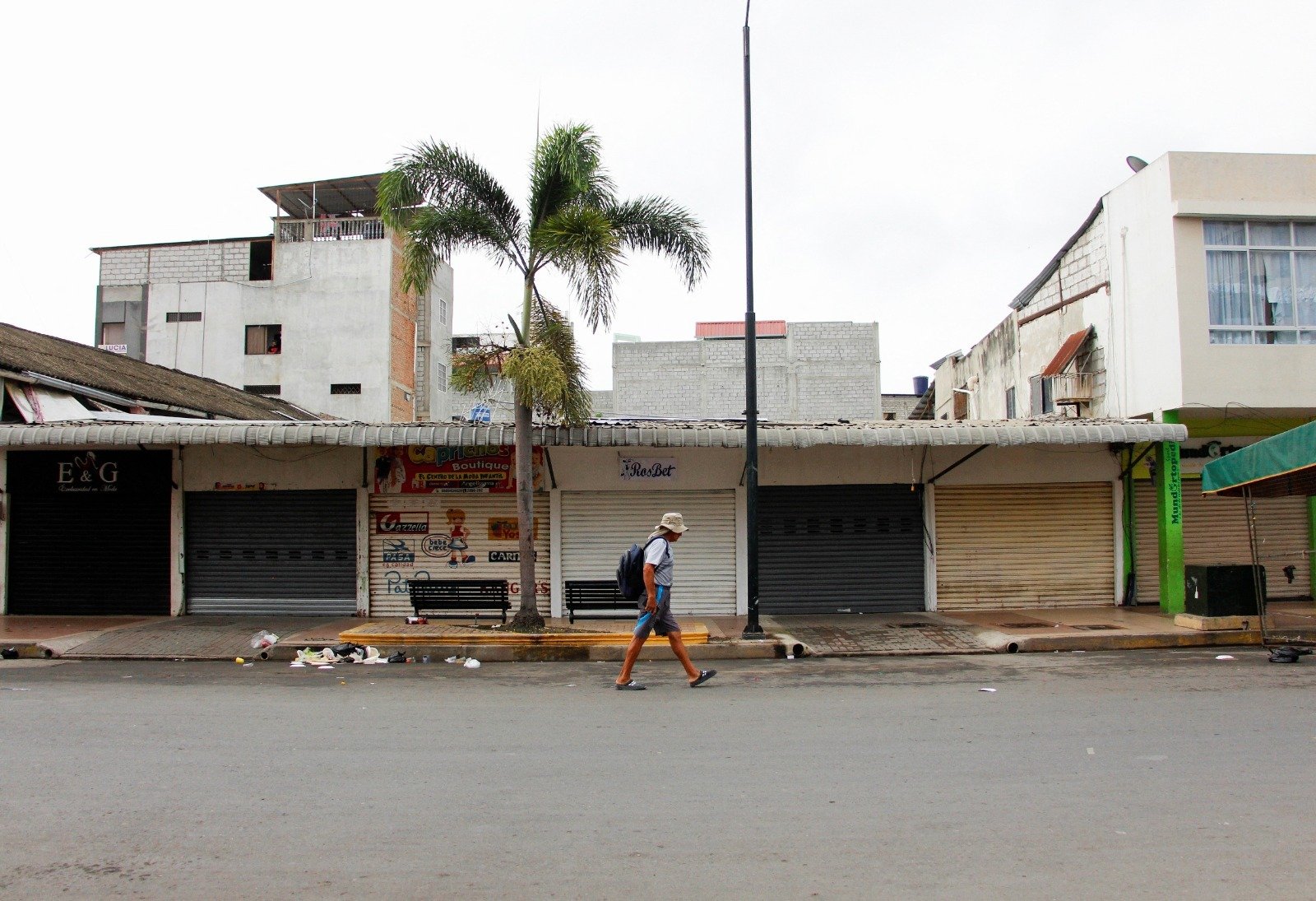 一名男子走过秘鲁边境附近一处平时繁忙的商业区，如今该区已关闭，厄瓜多尔骚乱促使秘鲁政府宣布与厄瓜多尔边境地区进入紧急状态。（图取自路透社）